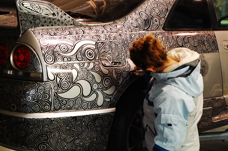 woman draws designs on car with sharpie