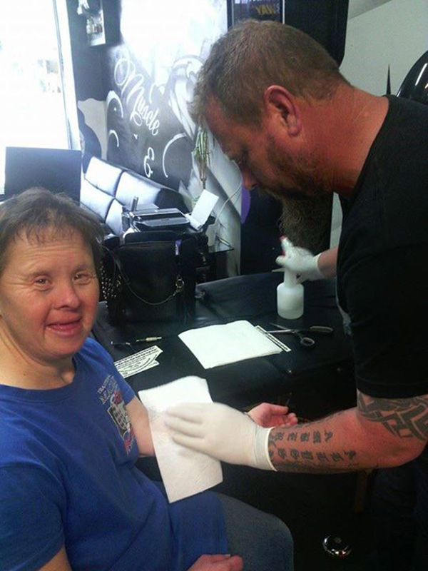 tattoo artist puts temporary tattoos on woman