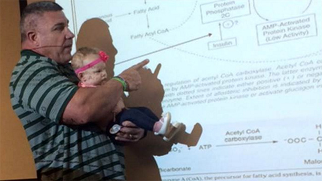 Baylor professor teaches class holding baby