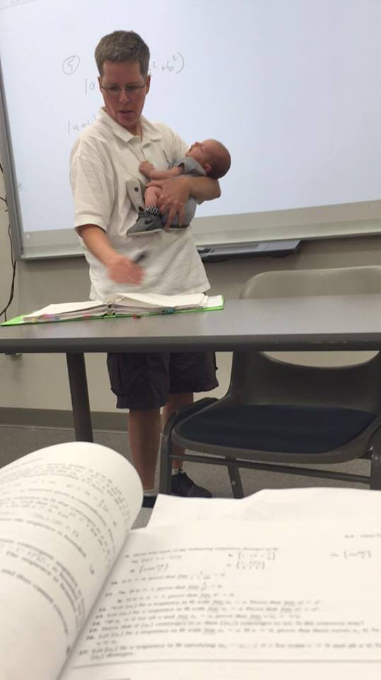 teacher holds baby for mom during lecture
