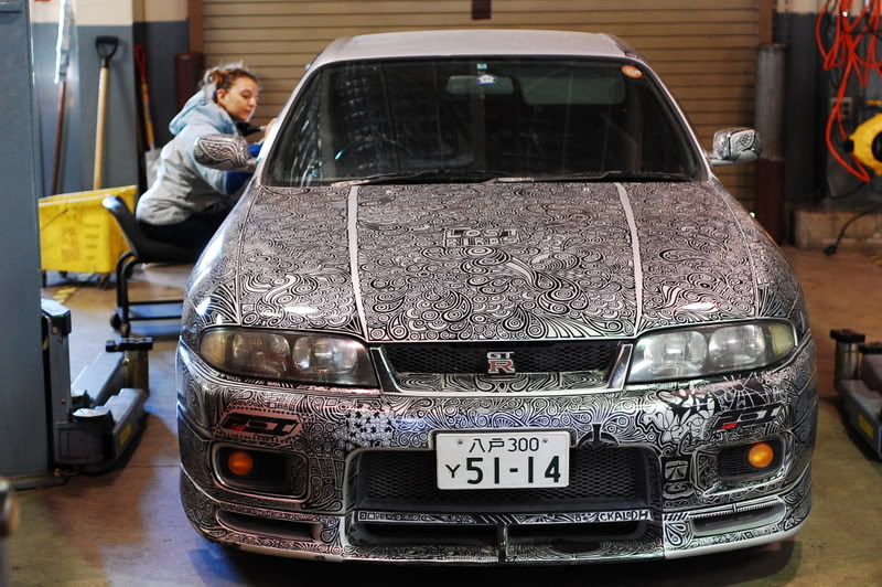 woman draws designs on car with sharpie