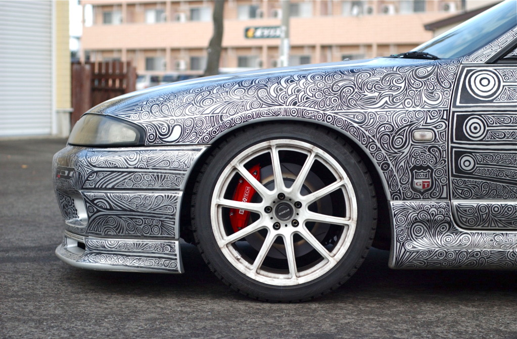 woman draws designs on car with sharpie