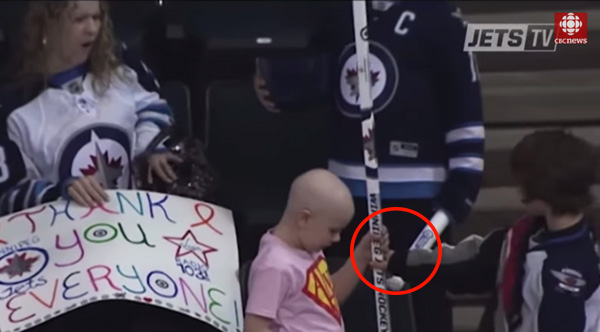 boy gives girl signed hockey stick