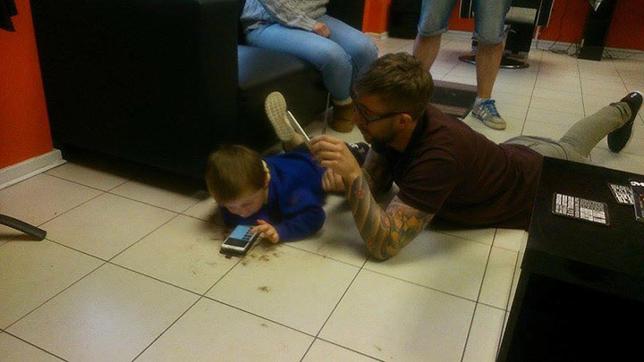 barber cuts hair on floor of boy with autism