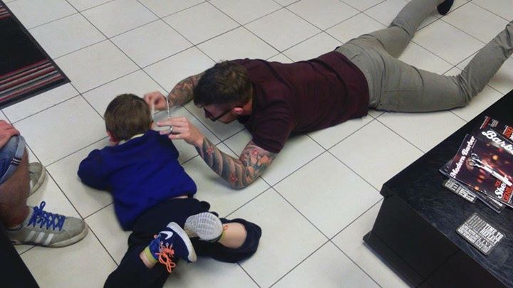 barber cuts hair on floor of boy with autism