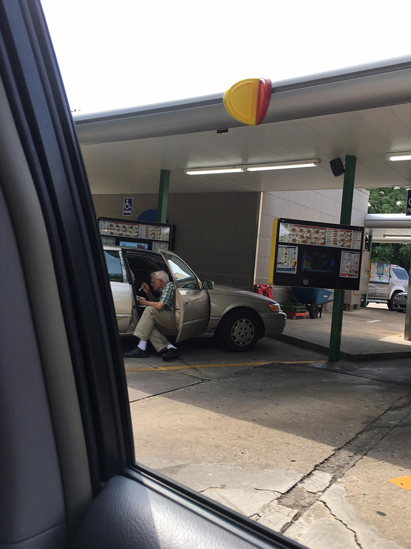 elderly man feeding wife ice cream in car