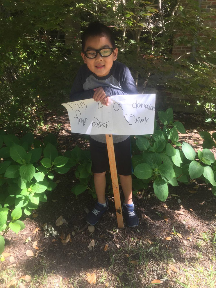 kid plays keyboard outside to raise money for cancer