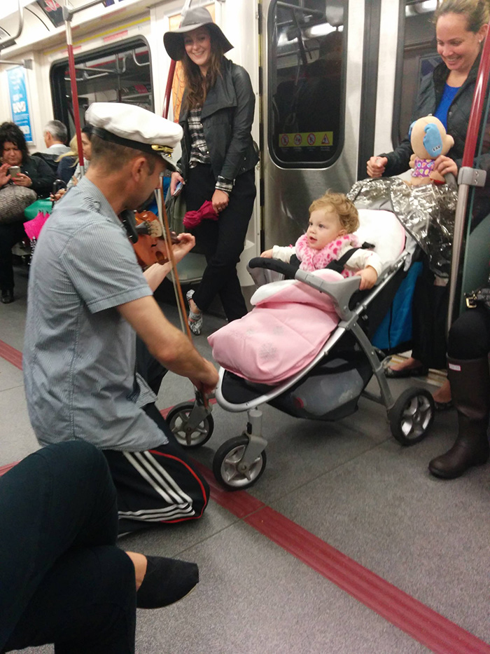 man plays violin for crying baby on subway
