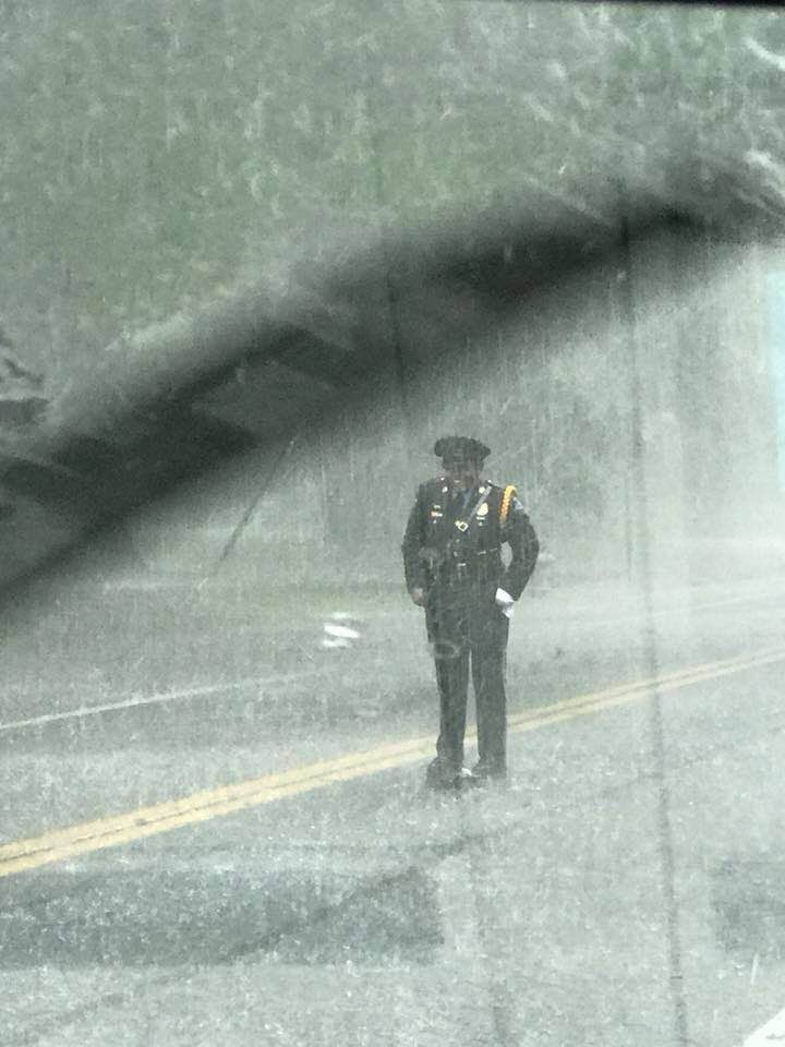 police officer stands over turtle in rain Sharnise Hawkins