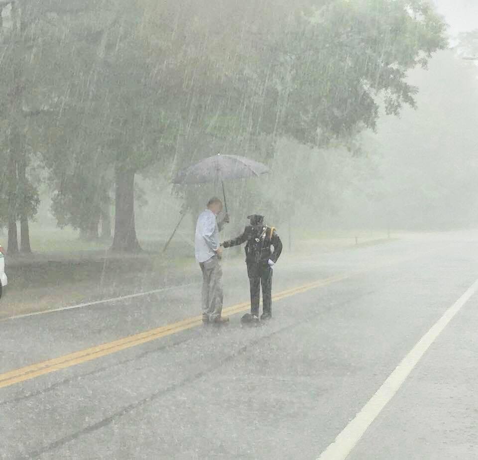 police officer stands over turtle in rain Sharnise Hawkins