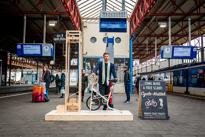 man makes scarf machine at train station