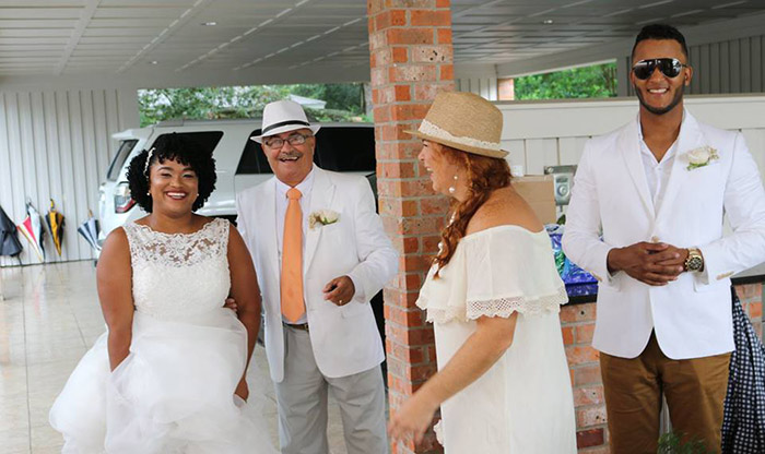 couple invites wedding guests into home when it rains on beach