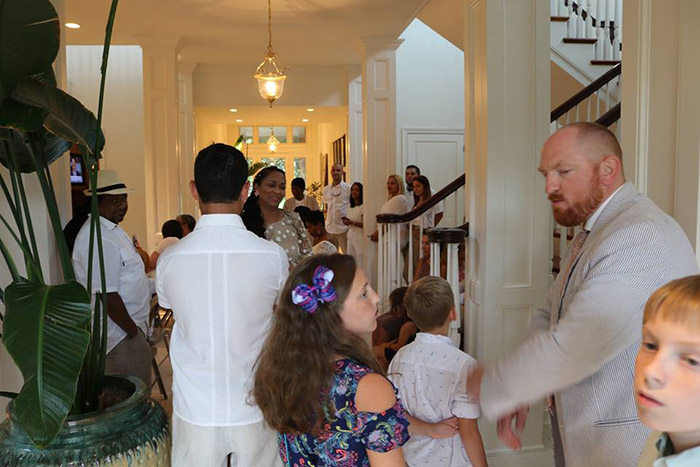 couple invites wedding guests into home when it rains on beach