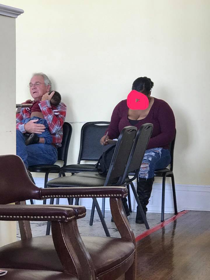 man holds baby for mom in waiting room doctor