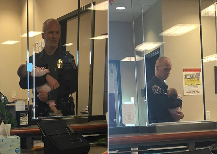police officer holds baby for mom