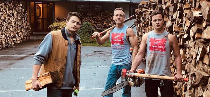 father and sons chop wood for needy