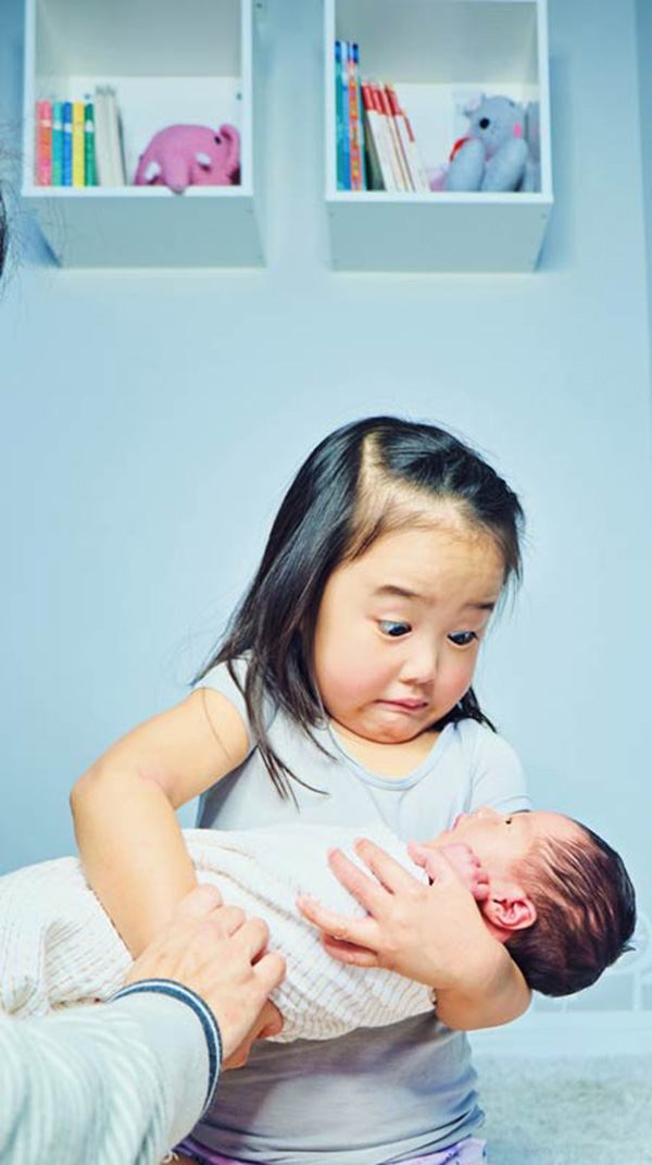 daughter funny reaction holding baby