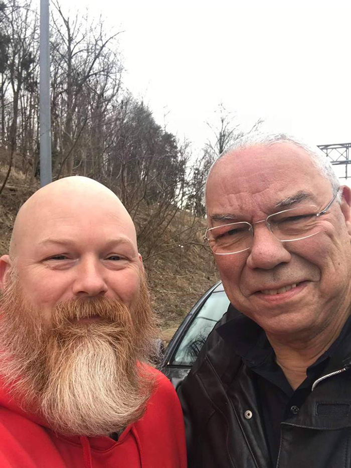 man helps general Powell on highway car tire