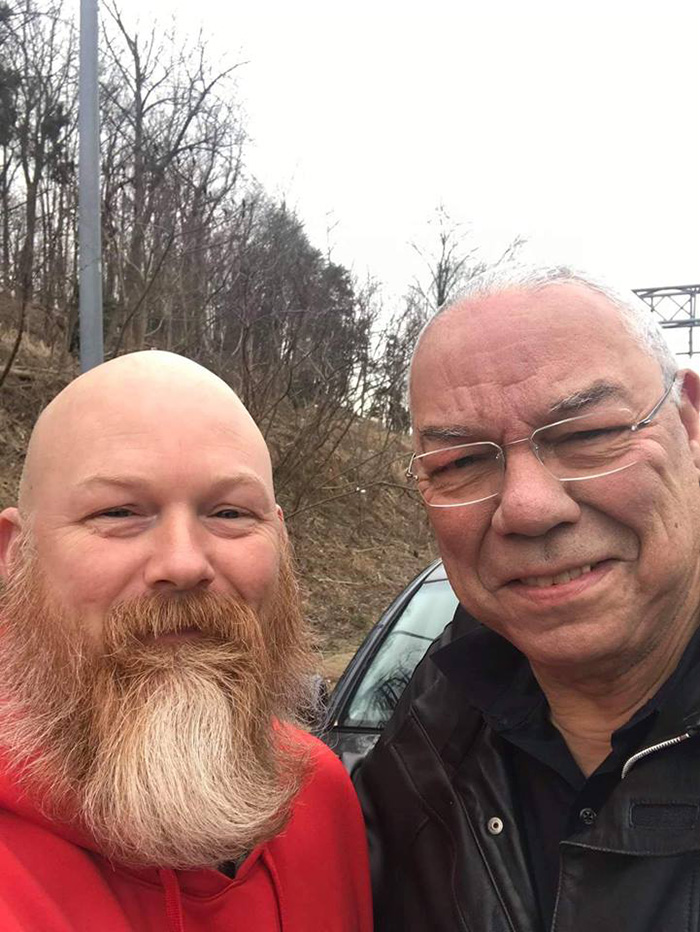 man helps general Powell on highway car tire