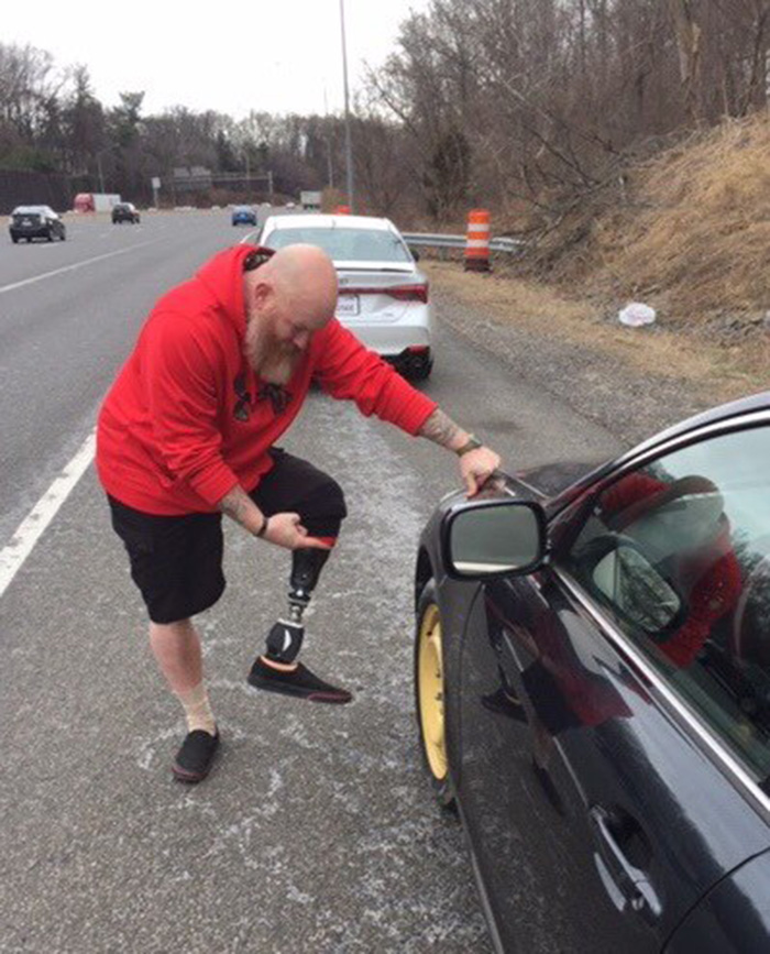 man helps general Powell on highway car tire