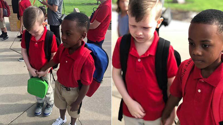 boy holds hand of crying kid first day of school