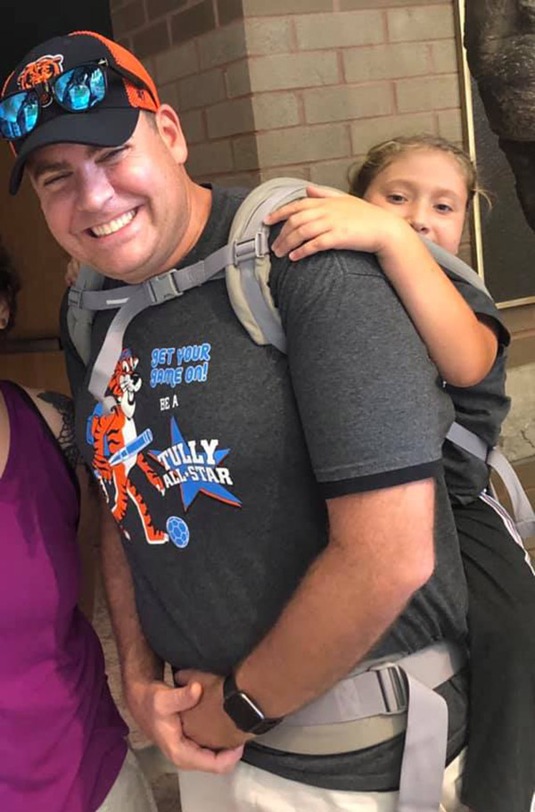 teacher carries student special needs field trip