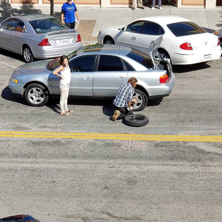homeless man helps woman change tire
