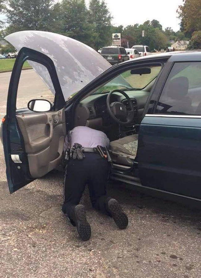 police officer helps fix car