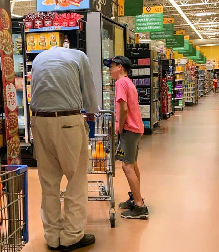boy helps elderly man shop at walmart