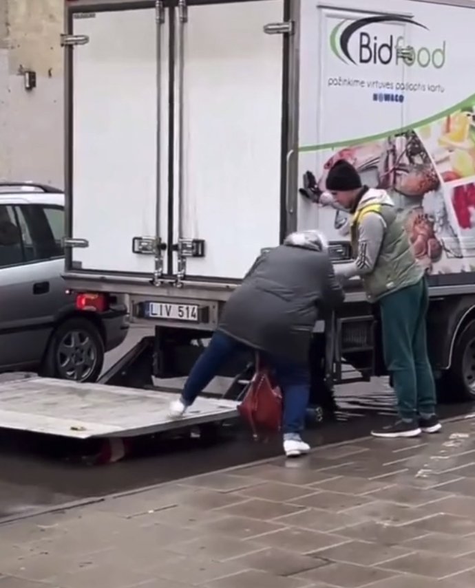 truck driver helps woman avoid puddle with lift