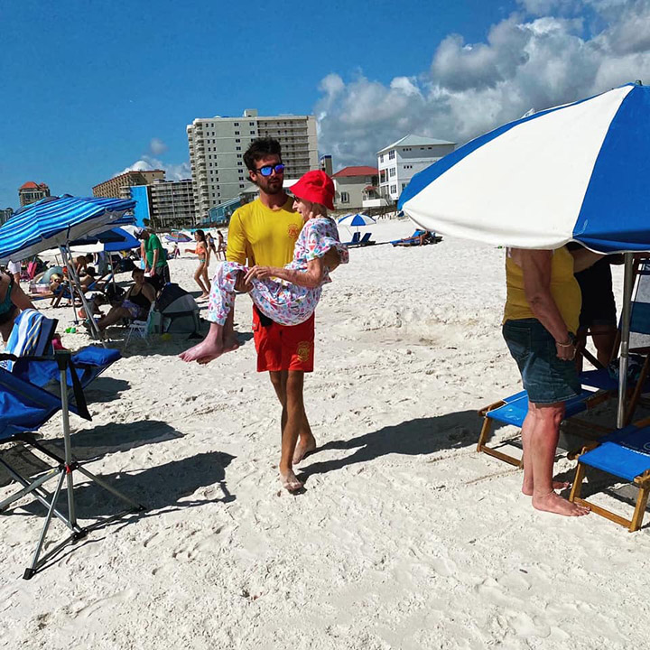 lifeguard carries older woman to beach every day