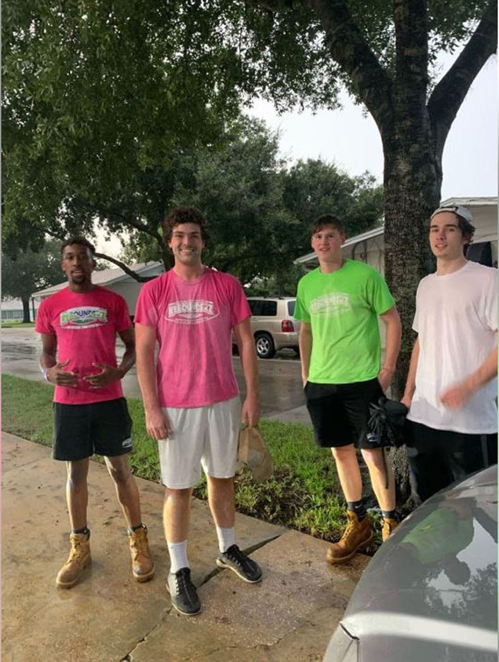 boys push woman in wheelchair in the rain