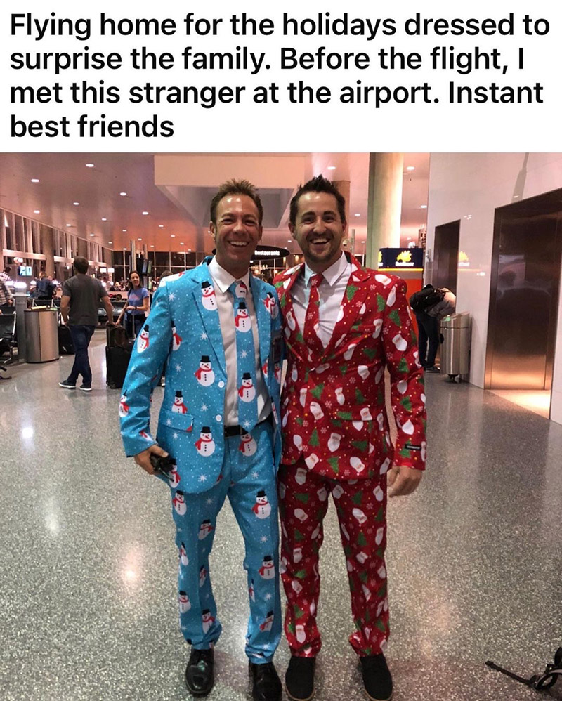 two men in Christmas suits at airport