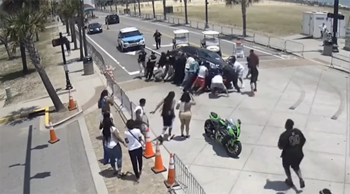 onlookers rescue motorcyclist trapped under car