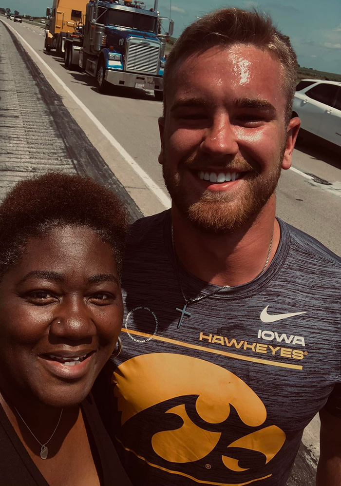 football player helps woman roadside assistance