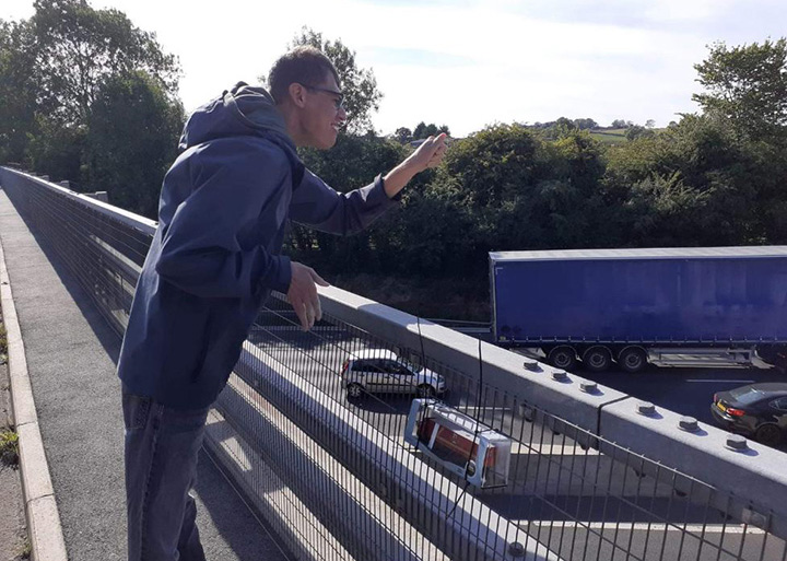 truck driver leaves toy truck for waving man on bridge
