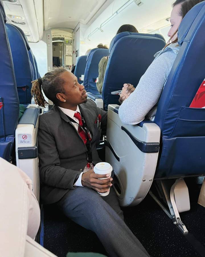 flight attendant helps frightened woman holding her hand