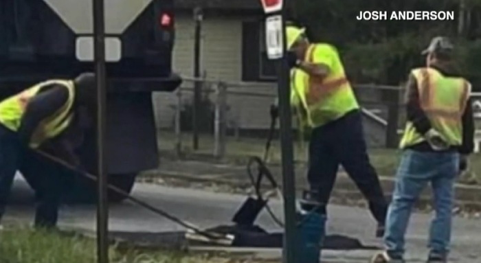 man plants tree in pot hole