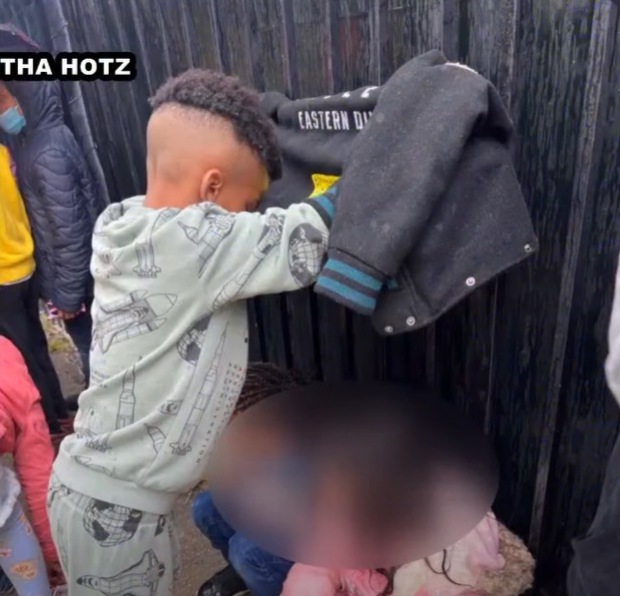 little boy shields classmates from rain with coat