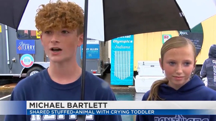 teen helps crying toddler at fair