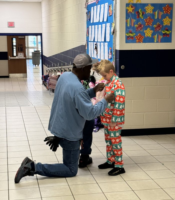 custodian helps kid with tie