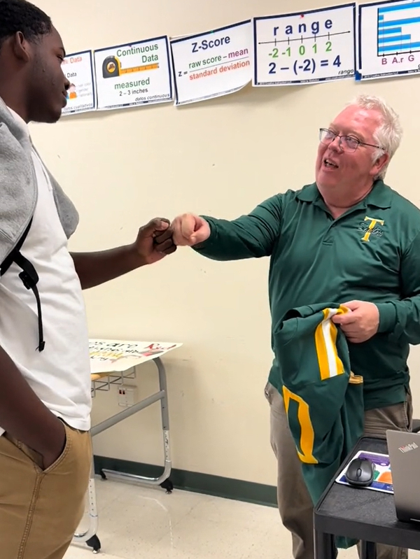 football players give teachers their jersey