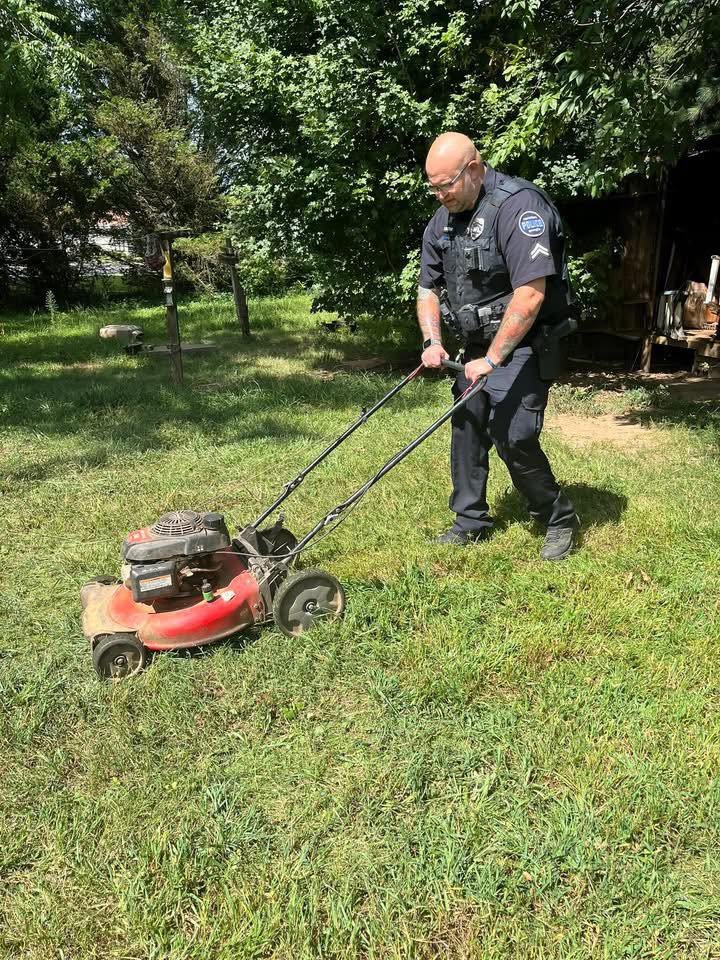officer cuts grass in summer heat stories