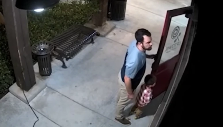 father and son stand guard candy store